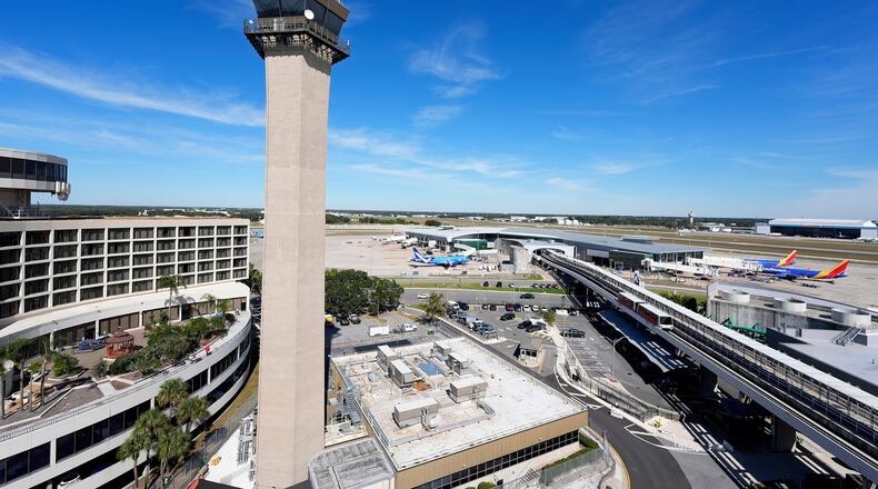 FILE - Airplanes are parked at gates near the air traffic control tower at the Tampa International Airport, Nov. 11, 2025, in Tampa, Fla. (AP Photo/Chris O'Meara, File)