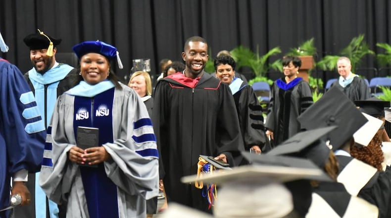 Everton Blair (center), district 4 member of the Gwinnett County Board of Education, with other school officials smiles as he leaves after the Shiloh High School graduation ceremony at Gwinnett Infinite Energy Center on Wednesday, May 22, 2019. Everton Blair, the first black and youngest member of the Gwinnett County Board of Education is also a graduate of Shiloh High School. At the graduation ceremony, he commemorated his 10 anniversary from the school by paying off any outstanding fines or fees that are keeping any of the graduates from receiving their diplomas. He also gave out three scholarships. "I may not be a billionaire," he said referencing Robert F. Smith's recent gift to Morehouse grads, "But every little bit helps." HYOSUB SHIN / HSHIN@AJC.COM