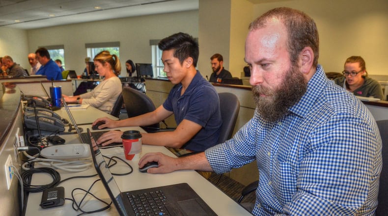 Josh Sterritt (foreground) of Smyrna, an Inventory Analyst for Home Depot works in the Hurricane Command Center set up by Home Depot. (Photo Chris Hunt/Special)