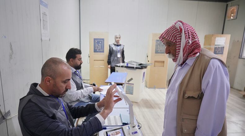 A displaced Yazidi man has his fingerprint verified before voting ahead of Iraq's parliamentary elections, set for Nov. 11, at a polling station in the Sharia camp near Dohuk, in Iraq's semi-autonomous Kurdish region, Sunday, Nov. 9, 2025. (AP Photo/Rashid Yahya)