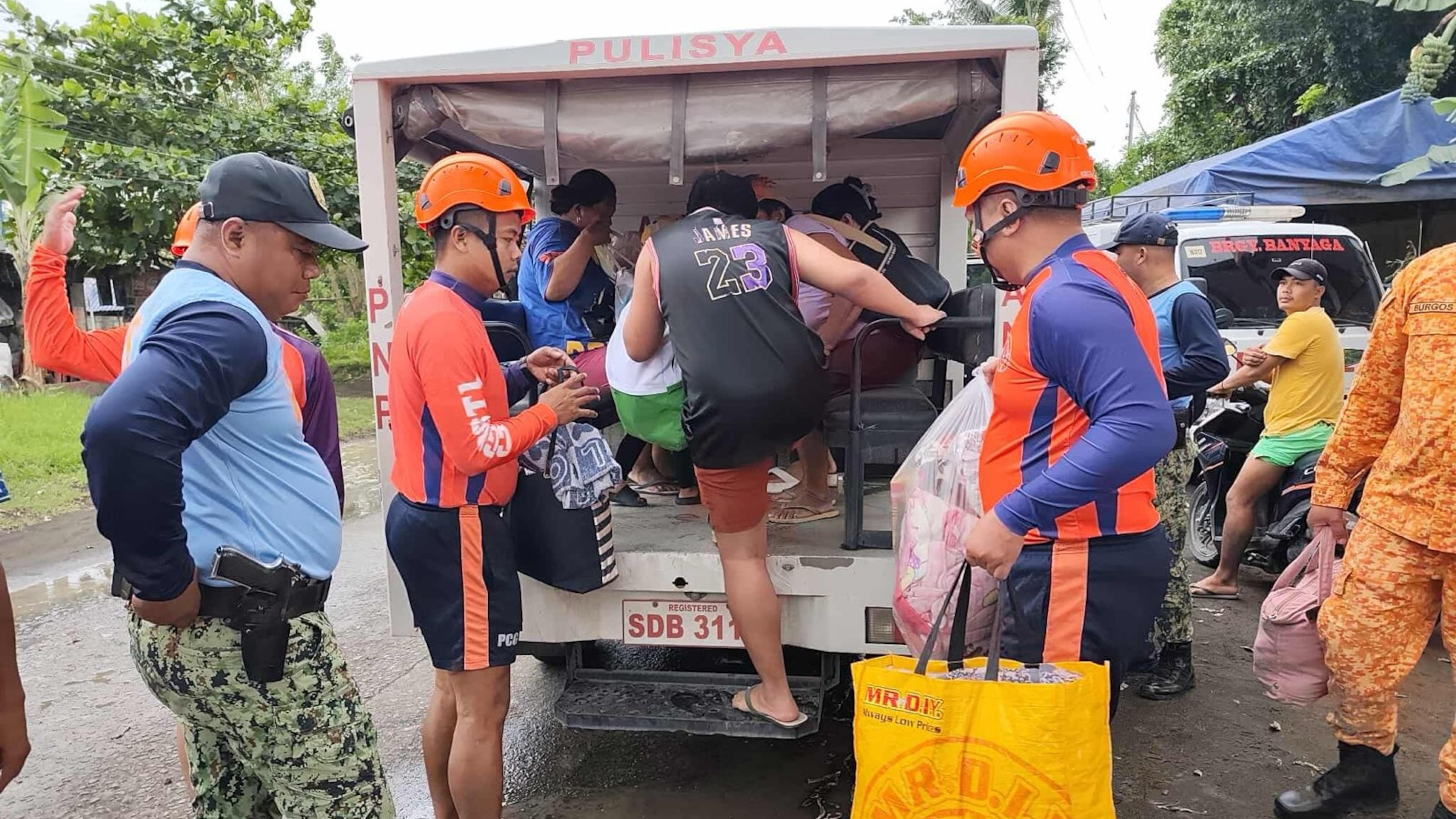 In this photo provided by the Philippine Coast Guard, rescuers evacuate people to safer grounds in Quezon province, eastern Philippines as Typhoon Fung-wong enters the country on Sunday Nov. 9 2025. (Philippine Coast Guard via AP)