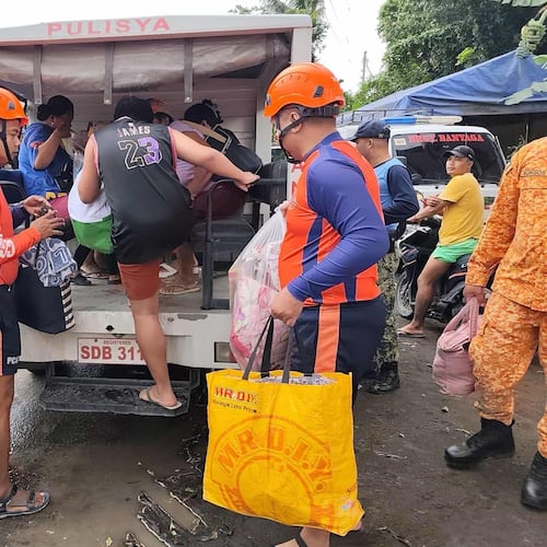 In this photo provided by the Philippine Coast Guard, rescuers evacuate people to safer grounds in Quezon province, eastern Philippines as Typhoon Fung-wong enters the country on Sunday Nov. 9 2025. (Philippine Coast Guard via AP)