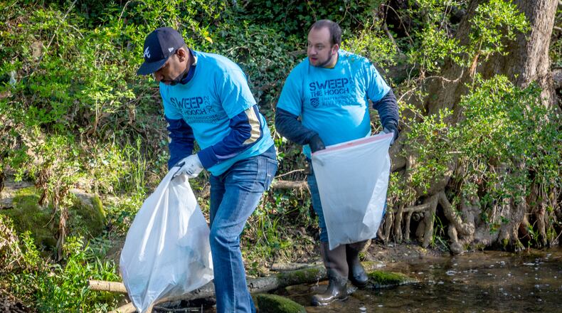Atlanta Councilmember Dustin Hillis (R) and Mayor of Atlanta Andre Dickens (L) bag trash along  Proctor Creek during Sweep The Hooch day in Atlanta Saturday, March 26, 2022. Proctor Creek runs through Atlanta and ultimately empties into the Chattahoochee River. STEVE SCHAEFER FOR THE ATLANTA JOURNAL-CONSTITUTION
