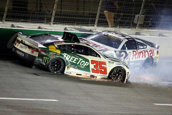 Driver Riley Herbst (35) and Todd Gilliland (34) collide in turn four during a NASCAR Cup Series auto race, Saturday, June 28, 2025, in Hampton, Ga. (AP Photo/Greg McWilliams)