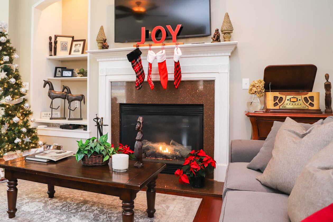 Silver and white covers the Christmas tree in Gail Burns-Grant’s family room. Her sister, who also made the wreath on the front door, decorated the tree for her with a nod to simplicity and snow, which Burns-Grant said she enjoys bringing into her home even though actual snow is scarce at her Georgia home. She also loves antiques and traditional style, so when she had trouble finding a vintage phonograph she purchased a wood-paneled reproduction from JCPenny that now sits in the family room. Text by Shannon Dominy/Photo by Reynolds Rogers