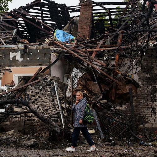 A woman walks in front of a house destroyed in a Russian strike on a residential neighbourhood in Kyiv, Ukraine, Thursday, Sept. 24, 2026. (AP Photo/Evgeniy Maloletka)