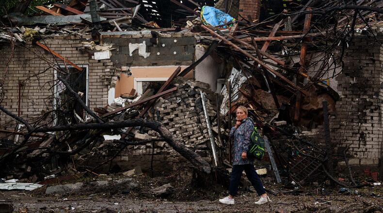 A woman walks in front of a house destroyed in a Russian strike on a residential neighbourhood in Kyiv, Ukraine, Thursday, Sept. 24, 2026. (AP Photo/Evgeniy Maloletka)