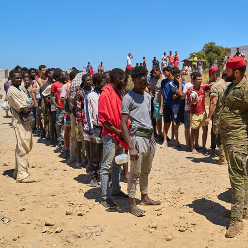 Migrants who crossed into Spain from Morocco line up for water distributed by Spanish soldiers in the Spanish enclave of Ceuta, Sunday, Aug. 2, 2026. (AP Photo/Bernat Armangue)