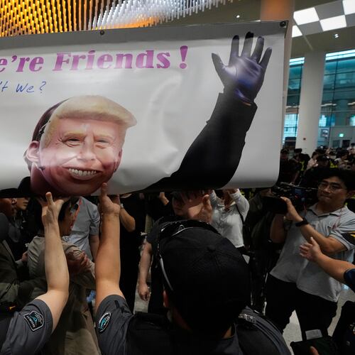Protesters try to hold a banner depicting U.S. President Donald Trump as police officers and members of airport security block at the arrival terminal of the Incheon International Airport, in Incheon, South Korea, Friday, Sept. 12, 2025. (Ahn Young-joon/AP)
