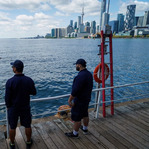 People look out across Lake Ontario from the harbor in Toronto, Tuesday, Aug. 25, 2026. (Keito Newman/The Canadian Press via AP)