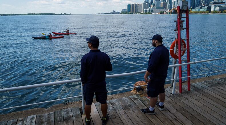 People look out across Lake Ontario from the harbor in Toronto, Tuesday, Aug. 25, 2026. (Keito Newman/The Canadian Press via AP)
