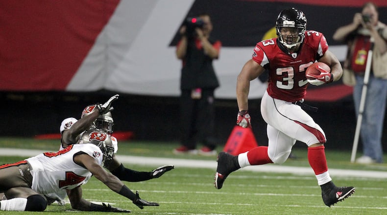 Jan. 1, 2012 Atlanta - Falcons running back Michael Turner breaks away from Buccaneers defenders for a 81-yard touchdown run and a 42-0 lead during 1st half action at the Georgia Dome in Atlanta on Sunday, Jan. 1, 2012.     Curtis Compton ccompton@ajc.com