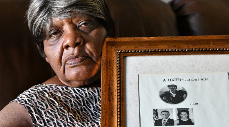 Ruby Jackson holds a framed "100th Birthday Wish" message from Barack and Michelle Obama for her father Charles Coleman, who died of COVID-19 at the age of 106. Coleman, born on July 4, 1914, was a longtime farmer. (Hyosub Shin / Hyosub.Shin@ajc.com)