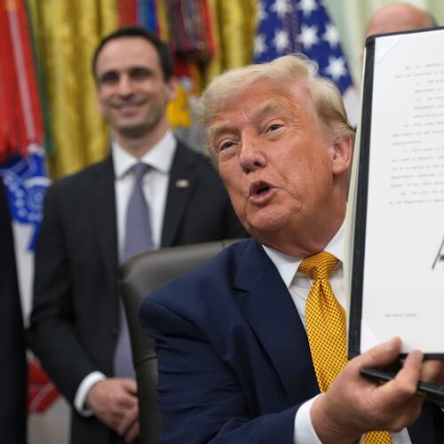President Donald Trump holds up a signed executive order about quantum computing, in the Oval Office of the White House, Monday, June 22, 2026, in Washington. (AP Photo/Jacquelyn Martin)