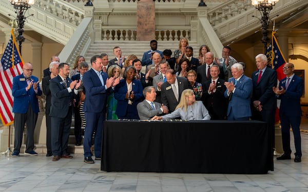 Gov. Brian Kemp signs House Bill 463 inside the Georgia Capitol building on Monday. (Ben Hendren for the AJC)