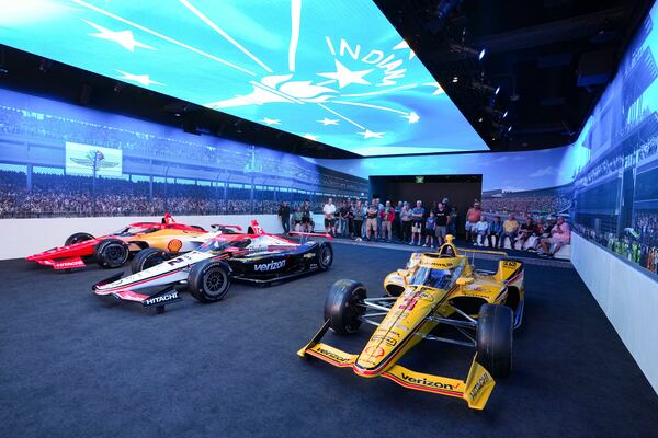 Visitors to the Indianapolis Motor Speedway Museum watch the "Starting Grid Experience" at the Indianapolis Motor Speedway in Indianapolis, Monday, May 19, 2025. (AP Photo/Michael Conroy)