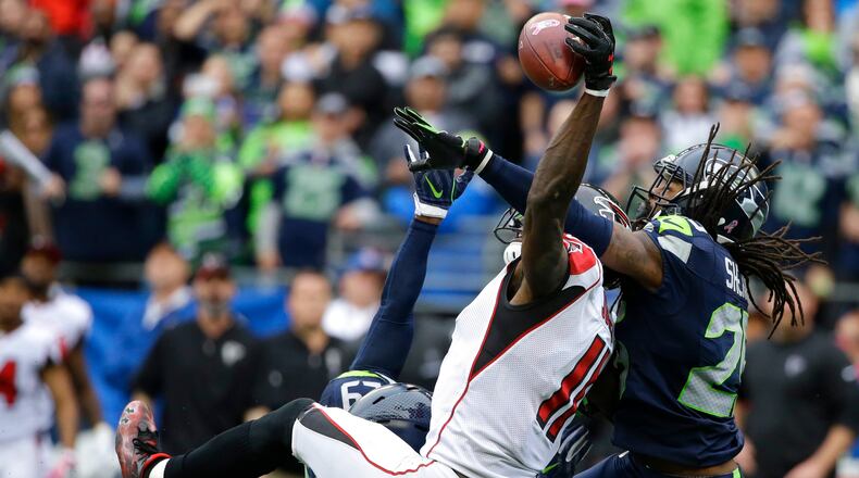 Seattle Seahawks cornerback Richard Sherman, right, and Earl Thomasbreak up a pass intended for Falcons receiver Julio Jones on Sunday, Oct. 16, 2016, in Seattle. The Seahawks beat the Falcons 26-24 but the teams meet again Saturday in the playoffs. (AP Photo/Elaine Thompson)
