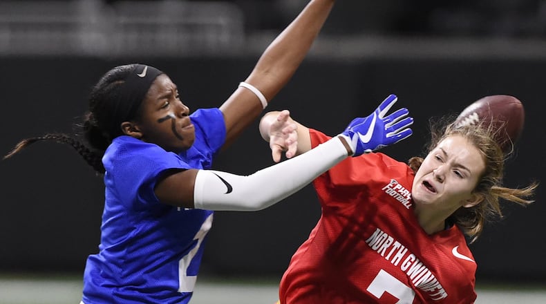 Peachtree Ridge’s Trinity Marshall, left, blocks North Gwinnett’s Sarah Kaufman’s pass during the finals of the flag football championships, Thursday, Dec. 20, 2018 at Mercedes Benz Stadium. North Gwinnett lost the game. (Annie Rice/AJC)