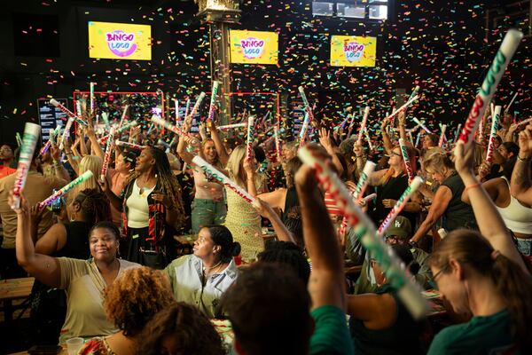 Partygoers throw their hands in the air, scream and dance as a DJ spins a throwback anthem during Bingo Loco, a touring bingo rave party, at Believe Music Hall in Atlanta on Saturday, July 18, 2026. The Ireland-born show turns traditional bingo into an immersive, festival-style stage production, complete with comedian emcees, dance-offs, lip-sync battles and confetti cannons, and has sold out shows in more than 200 cities worldwide. (Olivia Bowdoin for the AJC)