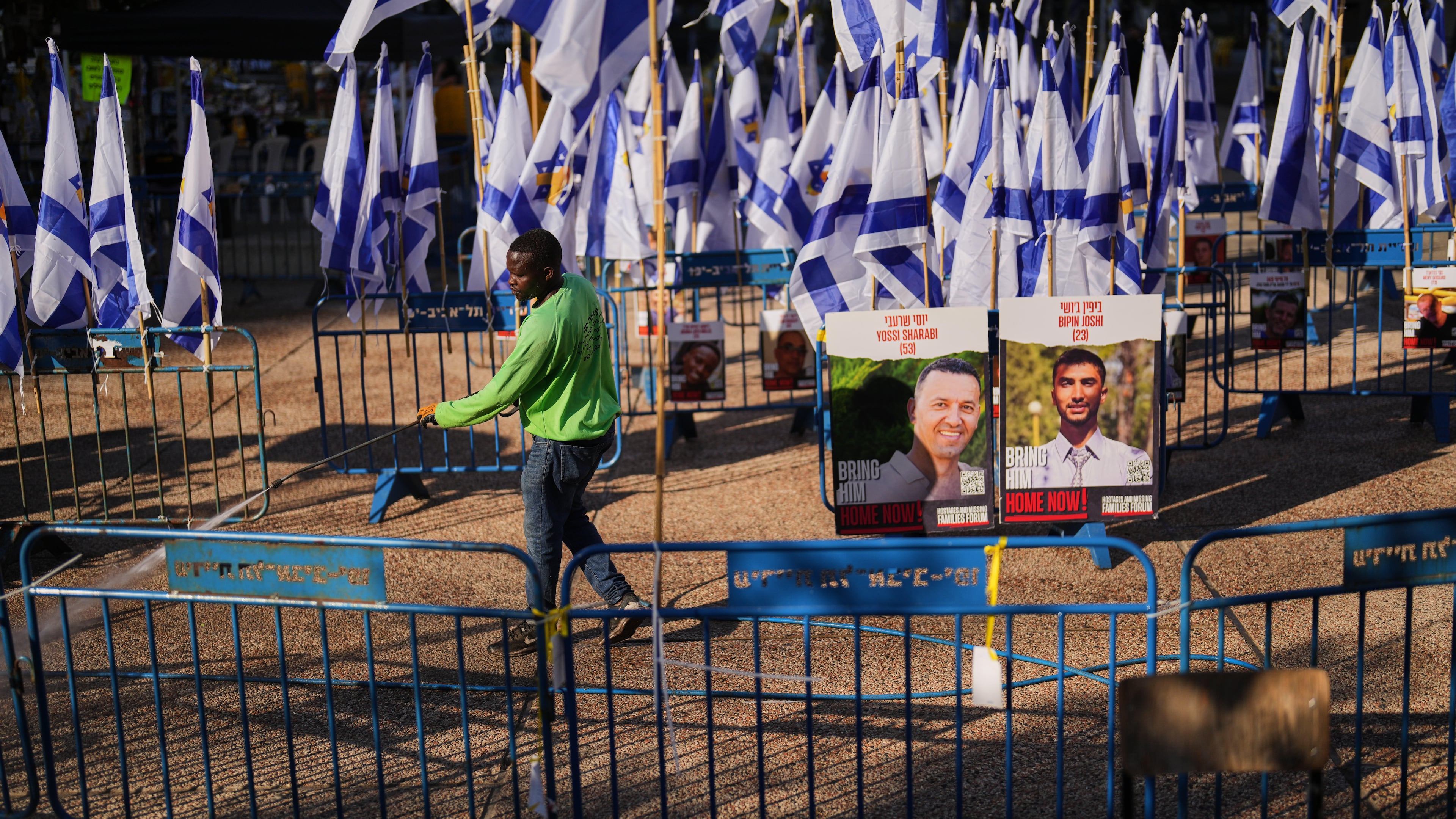 A worker cleans the ground at the plaza known as hostages square, in Tel Aviv, Israel, Tuesday, Oct. 14, 2025. (AP Photo/Francisco Seco)