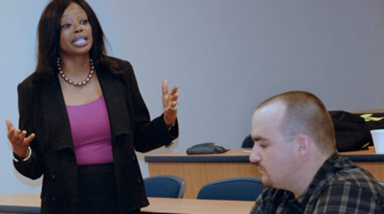 Jennifer S. Cantor, legal studies program chair at Herzing University’s Atlanta campus, discusses business law and corporate responsibility as Michael Knight listens.