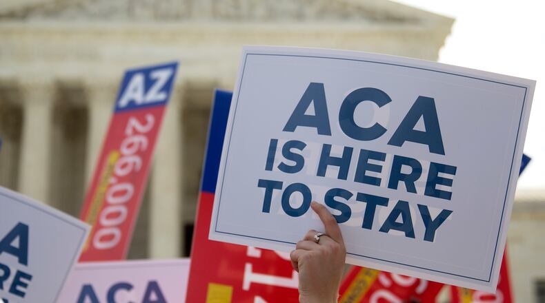 A demonstrator in support of U.S. President Barack Obama's health-care law, the Affordable Care Act (ACA), holds up a sign after the U.S. Supreme Court ruled 6-3 to save Obamacare tax subsidies outside the Supreme Court in Washington. Bloomberg/Andrew Harrer