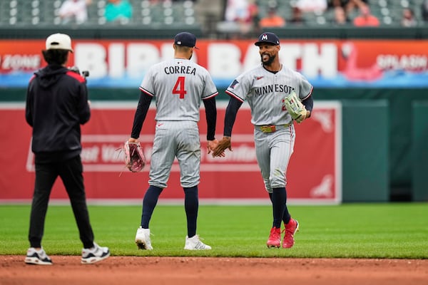 Minnesota Twins' Carlos Correa (4) and Byron Buxton, right, celebrate their team's victory over the Baltimore Orioles after the first baseball game of a doubleheader, Wednesday, May 14, 2025, in Baltimore. (AP Photo/Stephanie Scarbrough)