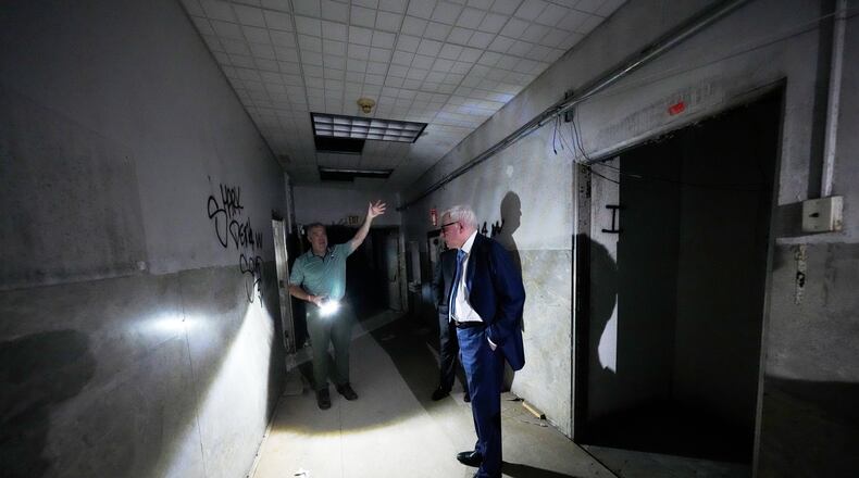 Patrick Norton, Tulane University senior vice president, chief operating officer and treasurer, right, and Jeff Benjamin, vice president of facilities and campus development, talk in a hallway inside the old Charity Hospital building Wednesday, Aug. 19, 2026, in New Orleans. (AP Photo/Gerald Herbert)