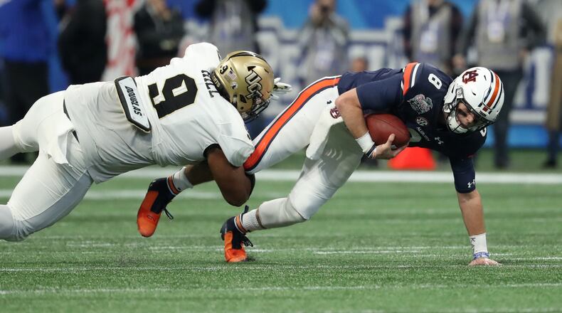 Down goes Auburn quarterback Jarrett Stidham - again - in last season's Chick-fil-a Peach Bowl loss to Central Florida. (PHOTO / JASON GETZ)