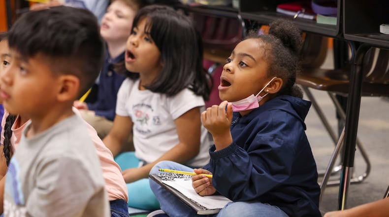 First grade students Destinee Walker (center) and Camila Sandoval (second from left) listen as their teacher explains the "science of reading," which emphasizes phonics, at Dunleith Elementary School on Friday, Feb. 3, 2023, in Marietta, Ga. (Jason Getz/AJC)