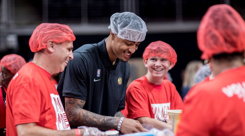 Atlanta Hawks player John Collins helps pack food with volunteers during the event to pack 1 million meals at State Farm Arena on Saturday, Oct. 5, 2019, in Atlanta. BRANDEN CAMP/SPECIAL TO THE AJC