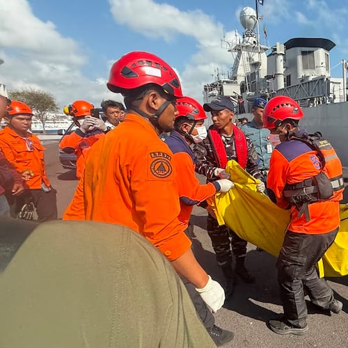 In this photo released by the Indonesian National Search and Rescue Agency (BASARNAS), rescuers carry the body of a victim of a ferry fire upon arrival at Indonesian Navy's 2nd Fleet's pier in Surabaya, East Java, Indonesia, Monday, Aug. 3, 2026. (BASARNAS via AP)