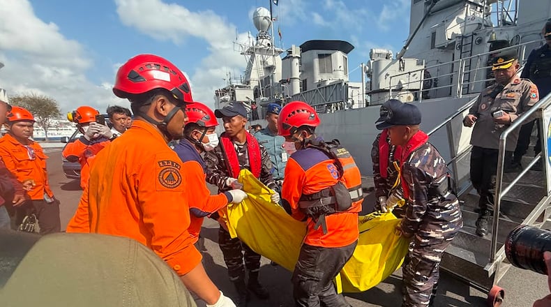 In this photo released by the Indonesian National Search and Rescue Agency (BASARNAS), rescuers carry the body of a victim of a ferry fire upon arrival at Indonesian Navy's 2nd Fleet's pier in Surabaya, East Java, Indonesia, Monday, Aug. 3, 2026. (BASARNAS via AP)
