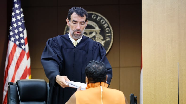 After hours of grand jury testimony, Fulton County Clerk Che Alexander receives a copy of the indictment from Judge Robert McBurney on Monday, Aug. 14, 2023, in Atlanta. (Miguel Martinez/The Atlanta Journal-Constitution/TNS)