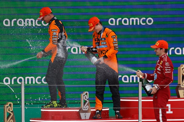 McLaren driver Oscar Piastri of Australia, center, celebrates on the podium with McLaren driver Lando Norris of Britain, left, and Ferrari driver Charles Leclerc of Monaco after winning the Spanish Grand Prix Formula One race at the Barcelona Catalunya racetrack in Montmelo, near Barcelona, Spain, Sunday, June 1, 2025. (AP Photo/Joan Monfort)