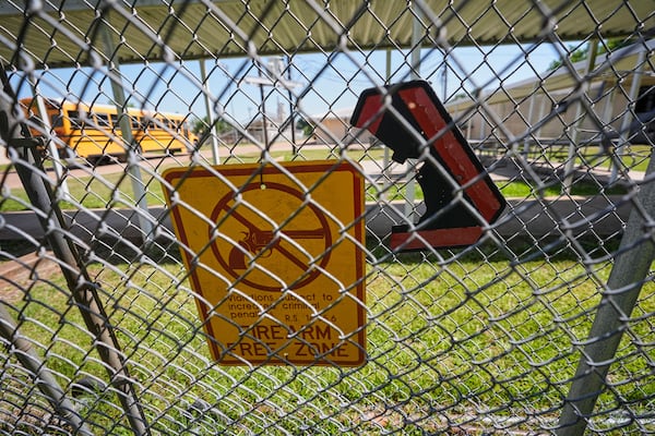 A signs warns of firearms on a fence at a gate for Ferriday High School in Ferriday, La., Thursday, May 22, 2025. (AP Photo/Gerald Herbert)