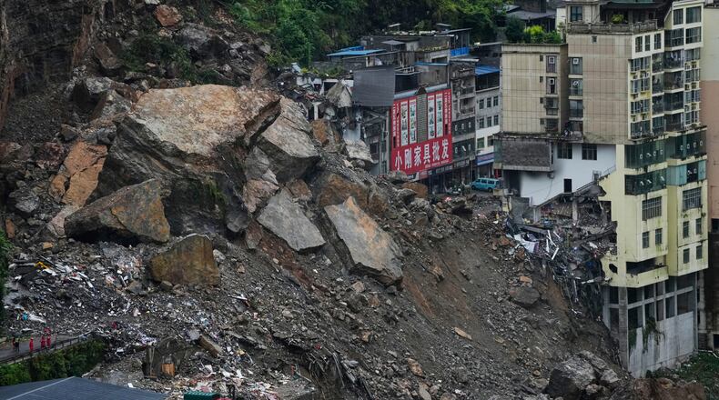 Residential and business buildings damaged by fallen rocks and mud are seen after a landslide in Pengshui County in southwestern China's Chongqing on Saturday, July 18, 2026. (AP Photo/Andy Wong)