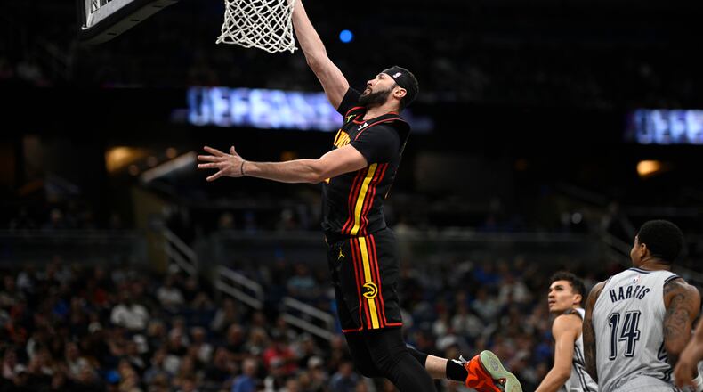 Atlanta Hawks forward Larry Nance Jr., left, goes up to shoot as Orlando Magic forward Tristan da Silva, second from right, and guard Gary Harris (14) watch during the first half of an NBA basketball game, Monday, Feb. 10, 2025, in Orlando, Fla. (AP Photo/Phelan M. Ebenhack)