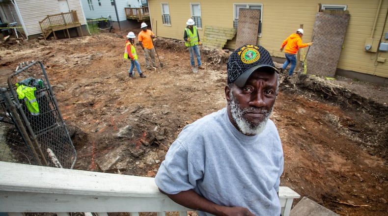 Ellis Smith stands on his porch last week as workers remove dirt from a Westside lead Superfund site in Atlanta's Vine City neighborhood. The cleanup of Smith’s yard is part of a massive EPA effort underway to remove lead from hundreds of Vine City properties, which comprise the Westside Lead Superfund site. (Steve Schaefer for The Atlanta Journal-Constitution)
