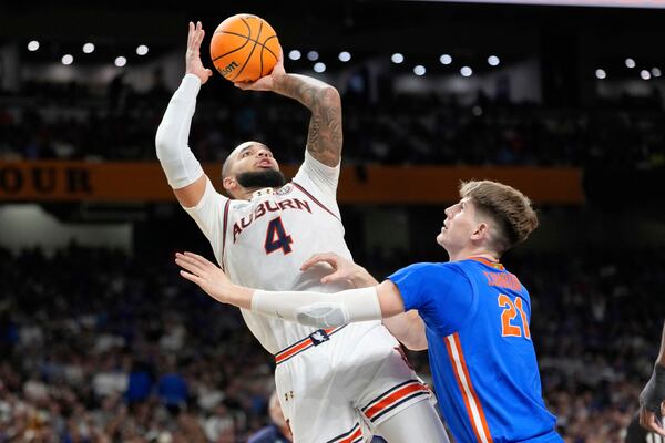 Auburn's Johni Broome (4) shoots as Florida's Alex Condon (21) defends during the second half in the national semifinals at the Final Four of the NCAA college basketball tournament, Saturday, April 5, 2025, in San Antonio. (AP Photo/Eric Gay)