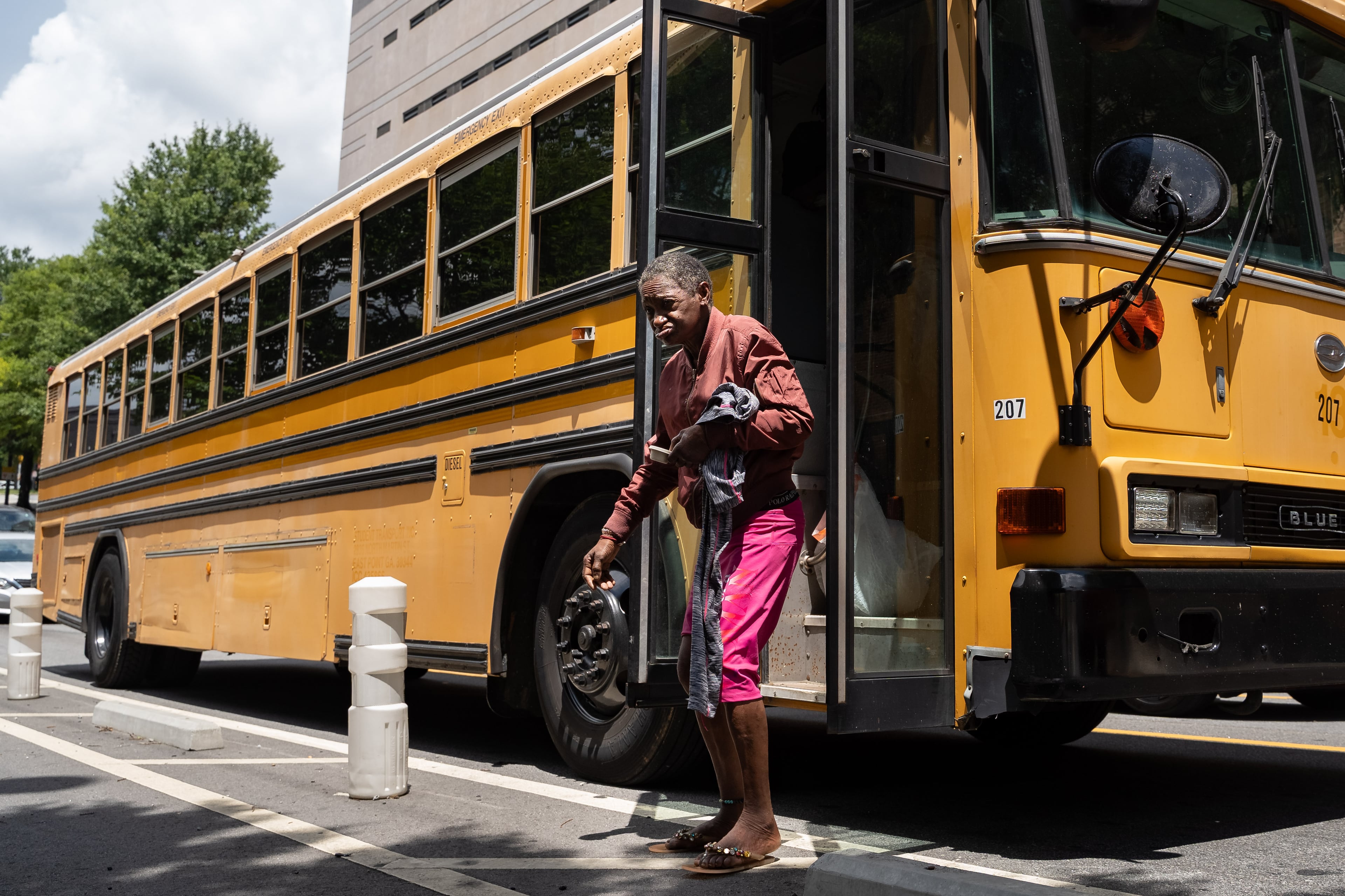 A bus drops off over 20 unhoused persons at Welcome House after they are relocated from Old Wheat Street. Thursday, July 10, 2025. (Ben Hendren for the AJC)