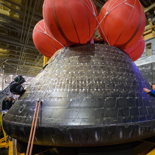 In this photo provided by NASA, Artemis II mission specialist and NASA astronaut Christina Koch hugs the Orion spacecraft aboard the USS John P. Murtha, Saturday, April 11, 2026, off the coast of California. (Bill Ingalls/NASA via AP)
