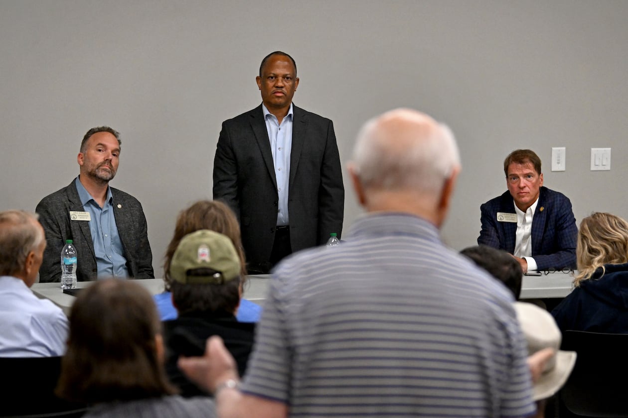 Jim Carter, foreground, questions Georgia Democratic state Reps. Eric Gisler, left, David Wilkerson, center, and Spencer Frye during a community conversation on taxes at the Bogart Library on Tuesday. The Republican-led General Assembly has focused on cutting income and property taxes. Meanwhile, a group of Democrats is touring the state to promote an alternative vision of government funding. (Hyosub Shin/AJC)