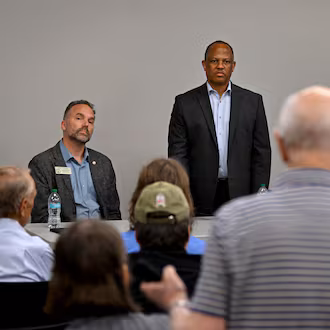 Jim Carter, foreground, questions Georgia Democratic state Reps. Eric Gisler, left, David Wilkerson, center, and Spencer Frye during a community conversation on taxes at the Bogart Library on Tuesday. The Republican-led General Assembly has focused on cutting income and property taxes. Meanwhile, a group of Democrats is touring the state to promote an alternative vision of government funding. (Hyosub Shin/AJC)