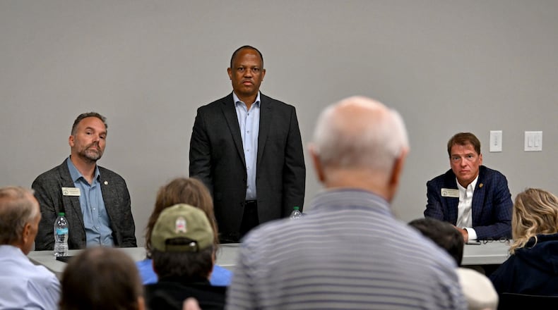 Jim Carter, foreground, questions Georgia Democratic state Reps. Eric Gisler, left, David Wilkerson, center, and Spencer Frye during a community conversation on taxes at the Bogart Library on Tuesday. The Republican-led General Assembly has focused on cutting income and property taxes. Meanwhile, a group of Democrats is touring the state to promote an alternative vision of government funding. (Hyosub Shin/AJC)