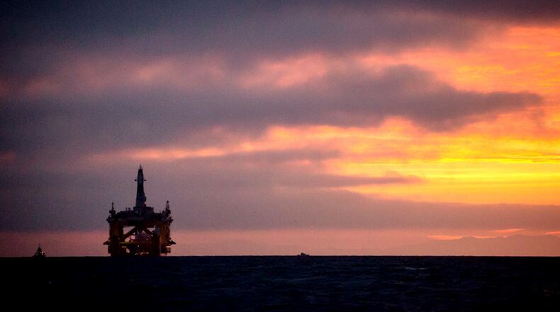In this 2015 file photo, an oil drilling rig arrives aboard a transport ship at sunrise, following a journey across the Pacific in Port Angeles, Wash. Daniella Beccaria/seattlepi.com via AP