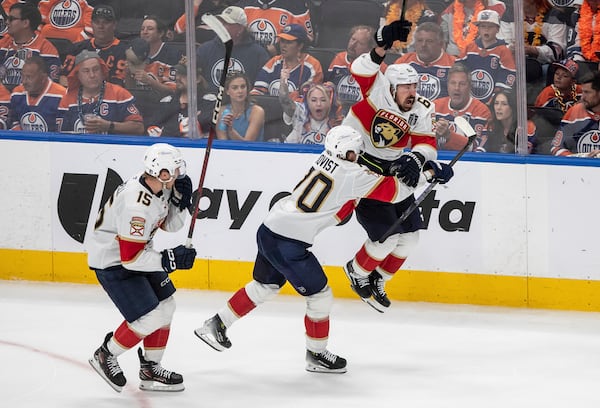 Florida Panthers' Brad Marchand (63) celebrates his game-winning goal against the Edmonton Oilers with Jesper Boqvist (70) and Anton Lundell (15) during the second overtime period in Game 2 of the NHL Stanley Cup final in Edmonton, Friday, June 6, 2025. (Jason Franson/The Canadian Press via AP)