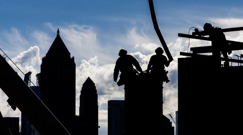 Construction workers pour concrete into forms along Bishop Street near 17th Street in West Midtown Atlanta in 2024 as they work on a mixed-use project called UrbA ATL. Much has changed over the past 30 years in Atlanta, both the city and the region, in terms of size, diversity, and population. (John Spink/AJC 2024)