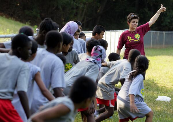 Luma Mufleh runs a drill during boys and girls soccer practice in Clarkston in September 2012. AJC FILE PHOTO