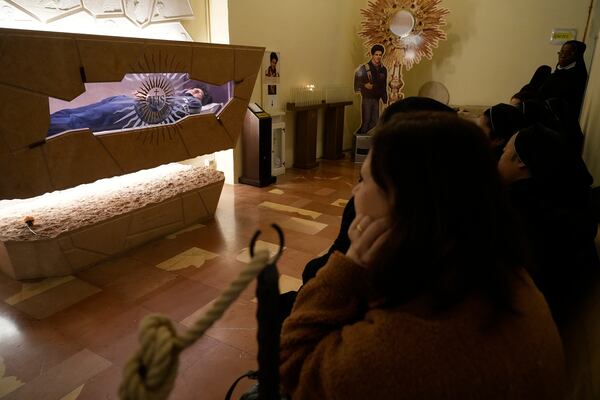 Worshippers pay their respects at the tomb of 15-year-old Carlo Acutis, an Italian boy who died in 2006 of leukemia, in Assisi, Italy, on Saturday, March 1, 2025. (AP Photo/Gregorio Borgia)